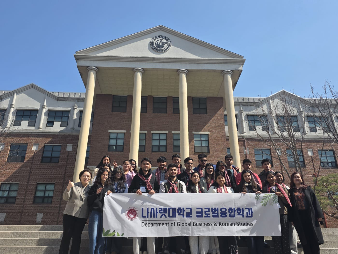 Students with a Department of Global Business and Korean Studies banner at Korea Nazarene University
